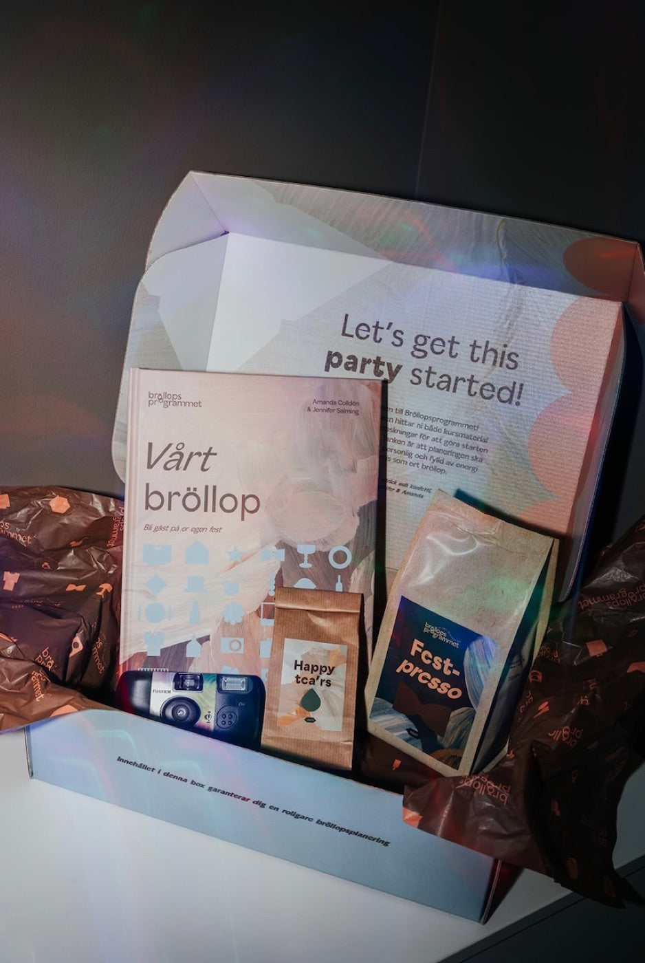 Bröllopsprogrammets välkomstbox med häfte, engångskamera och fika